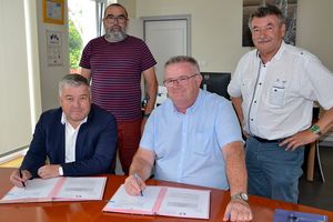 Séance de signature avec 4 hommes : Laurent Péron, vice-président de Brest métropole (à gauche) et Fabrice Jacob, maire de Guipavas lors de la signature en présence de Pierre Grandjean et Jacques Gosselin respectivement conseiller délégué aux travaux et adjoint aux travaux et à l'environnement.