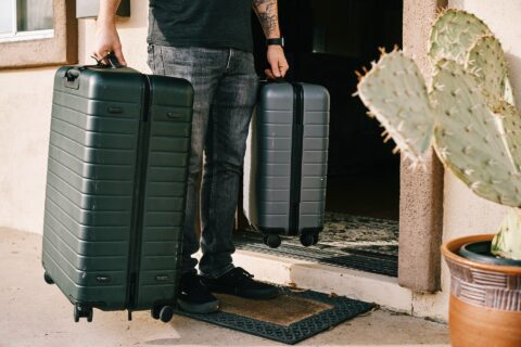 homme partant en vacances avec 2 grosses valise grises