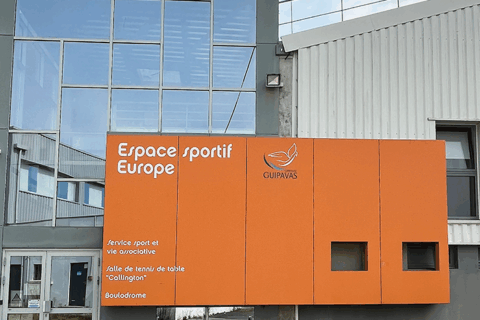 Bâtiment à la façade orangée sur lequel est inscrit "Espace sportif Europe".
