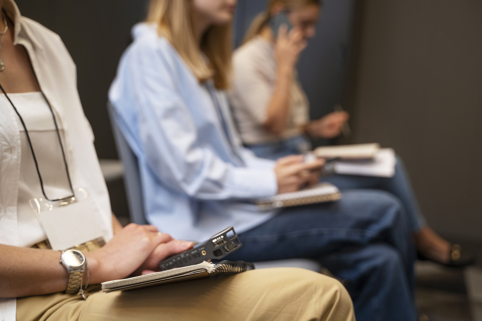 Femmes assises dans une salle d'attente. On ne voit pas bien les personnes. Ambiance feutrée et photo légèrement floue.